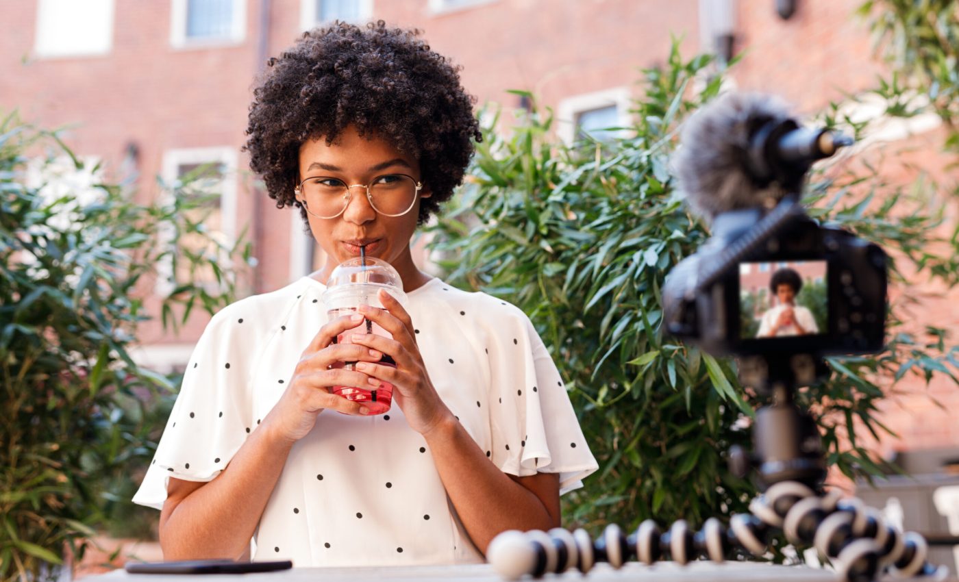 Girl drinking juice while making content for video blog